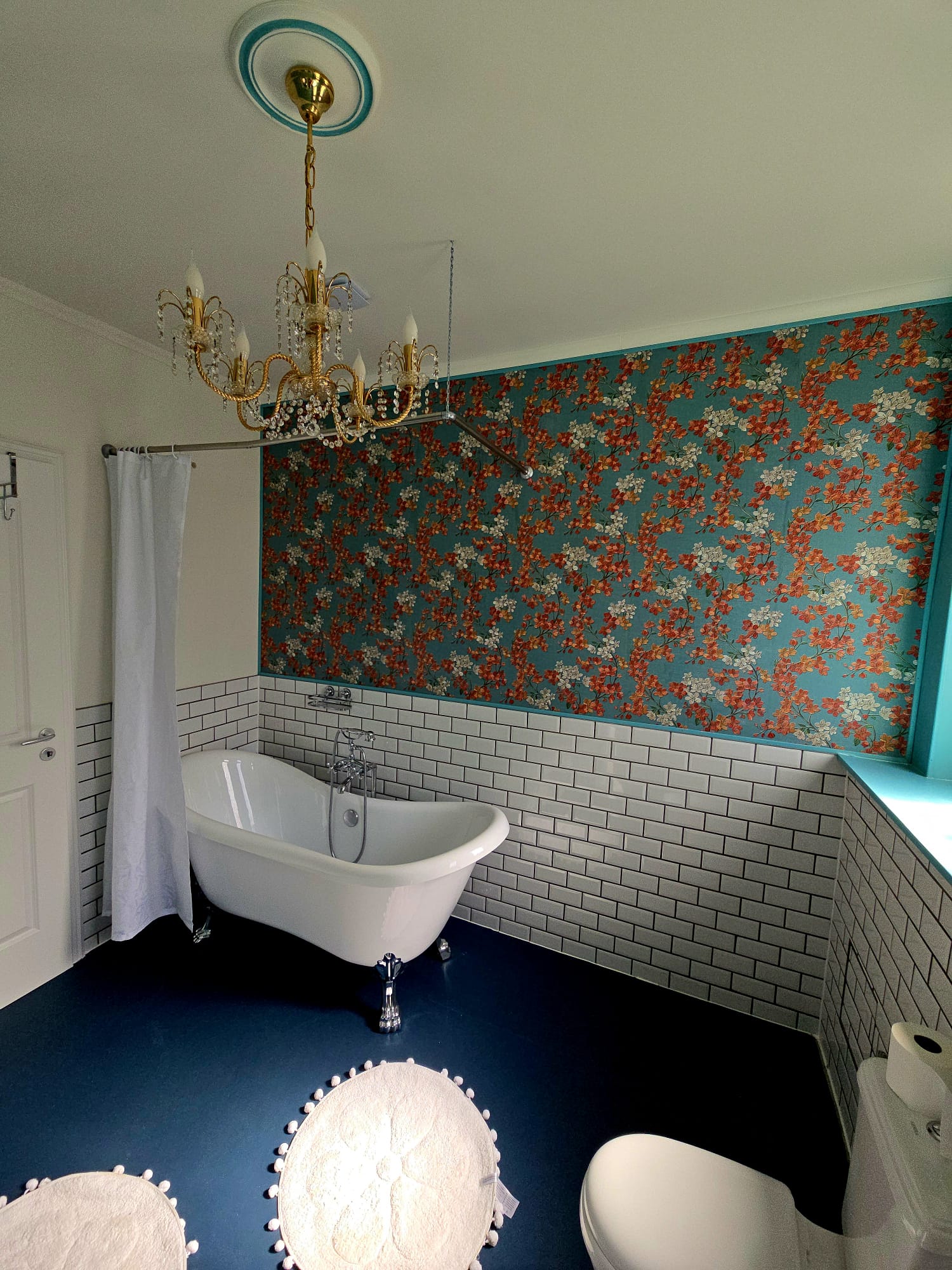 Zimmer 12 — Bad mit freistehender Badewanne und Blütentapete